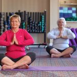 Two ladies practice yoga in our fitness center