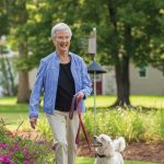 A happy woman walks her dog in the neighborhood