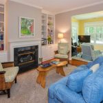 A furnished living room with a fireplace looking toward a sunroom