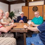 Four men enjoy playing cards