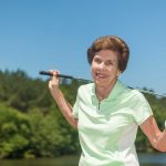 A woman pauses while enjoying a round of golf