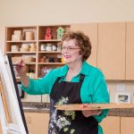 A woman enjoys painting in our life enrichment center