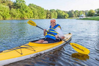 A woman enjoys kayaking on the lake