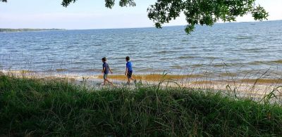 Two boys walk along the beach at Belle Isle