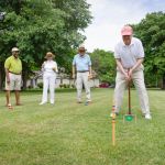 Happy group playing croquet