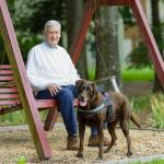 Man on a swing with his dog