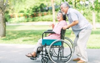 senior man pushing senior woman in wheelchair