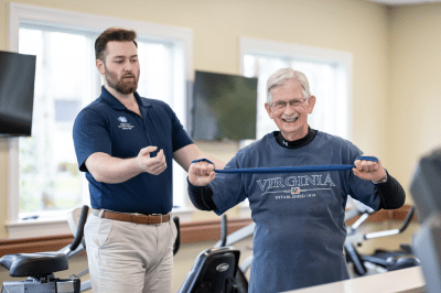 senior man exercising with male trainer