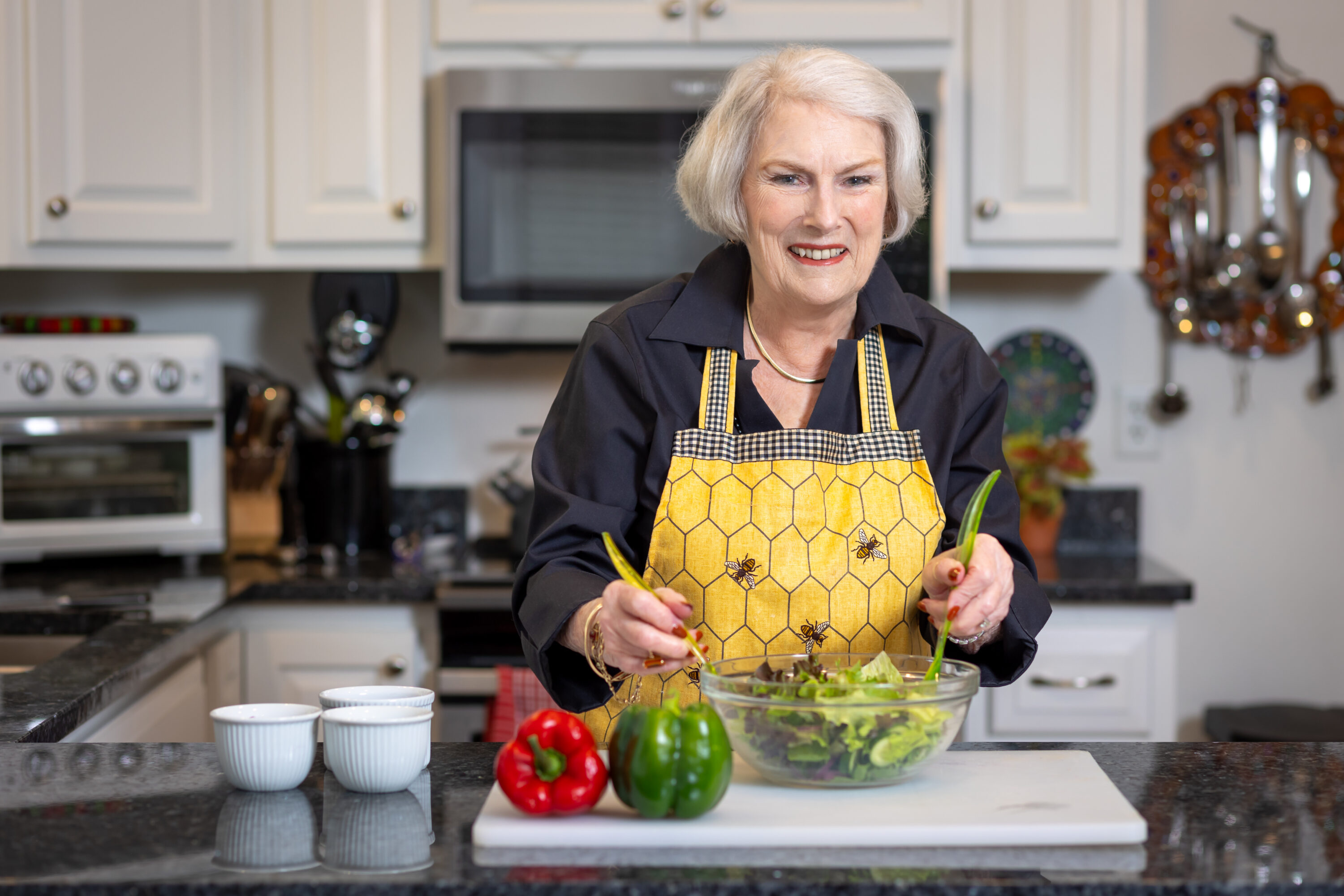 Senior woman mixing salad in home kitchen