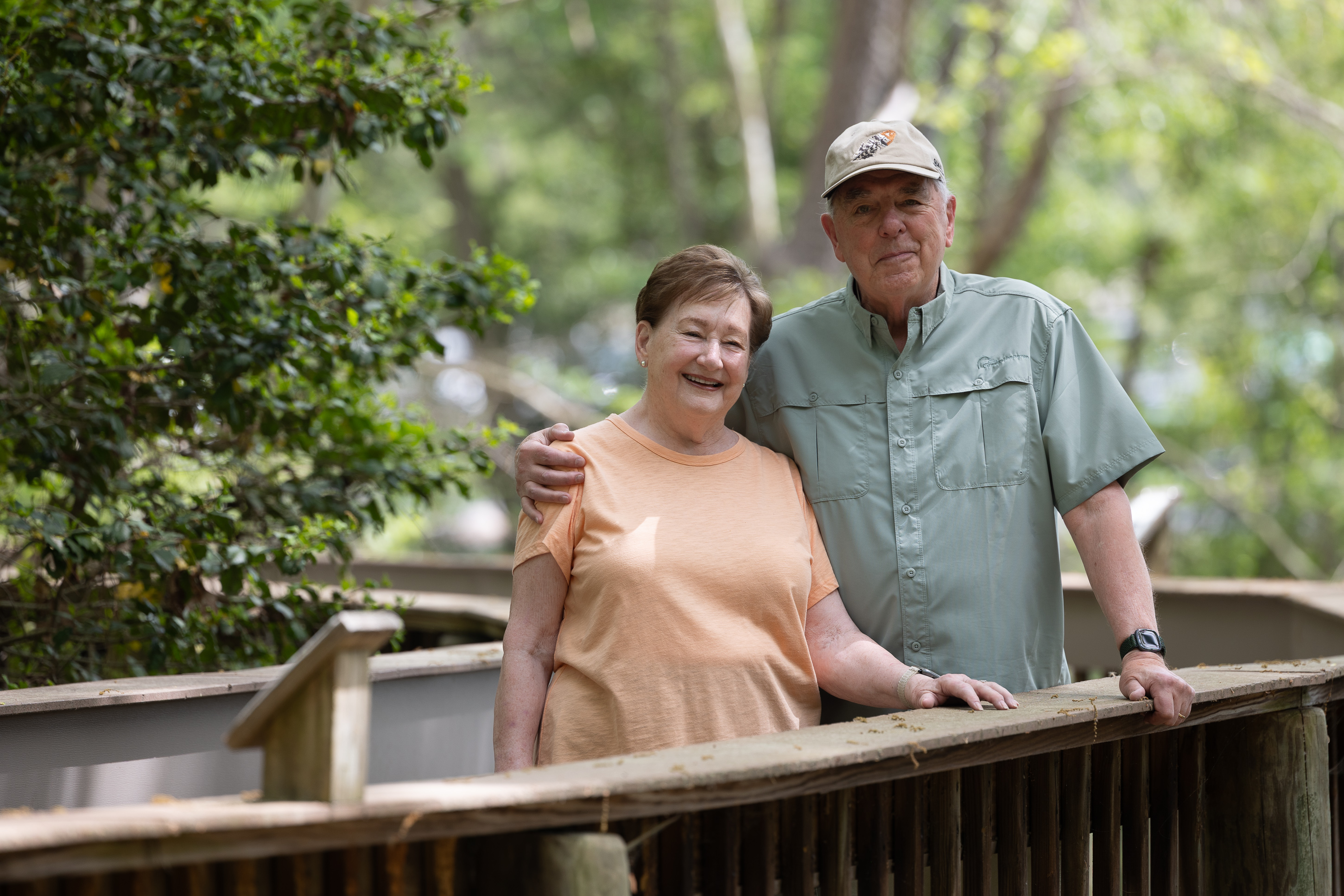 Smiling older couple on wooden park boardwalk