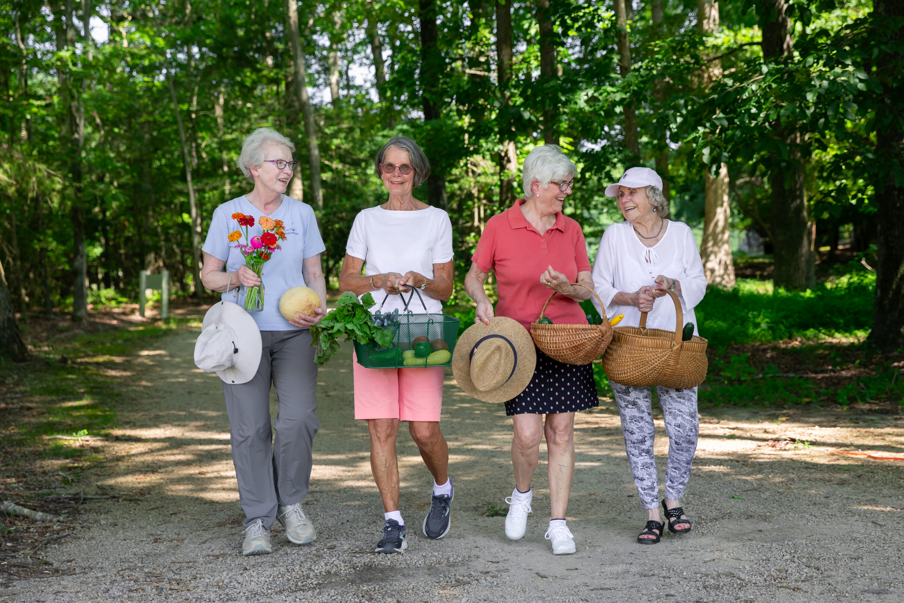 Four senior women walking with baskets in park