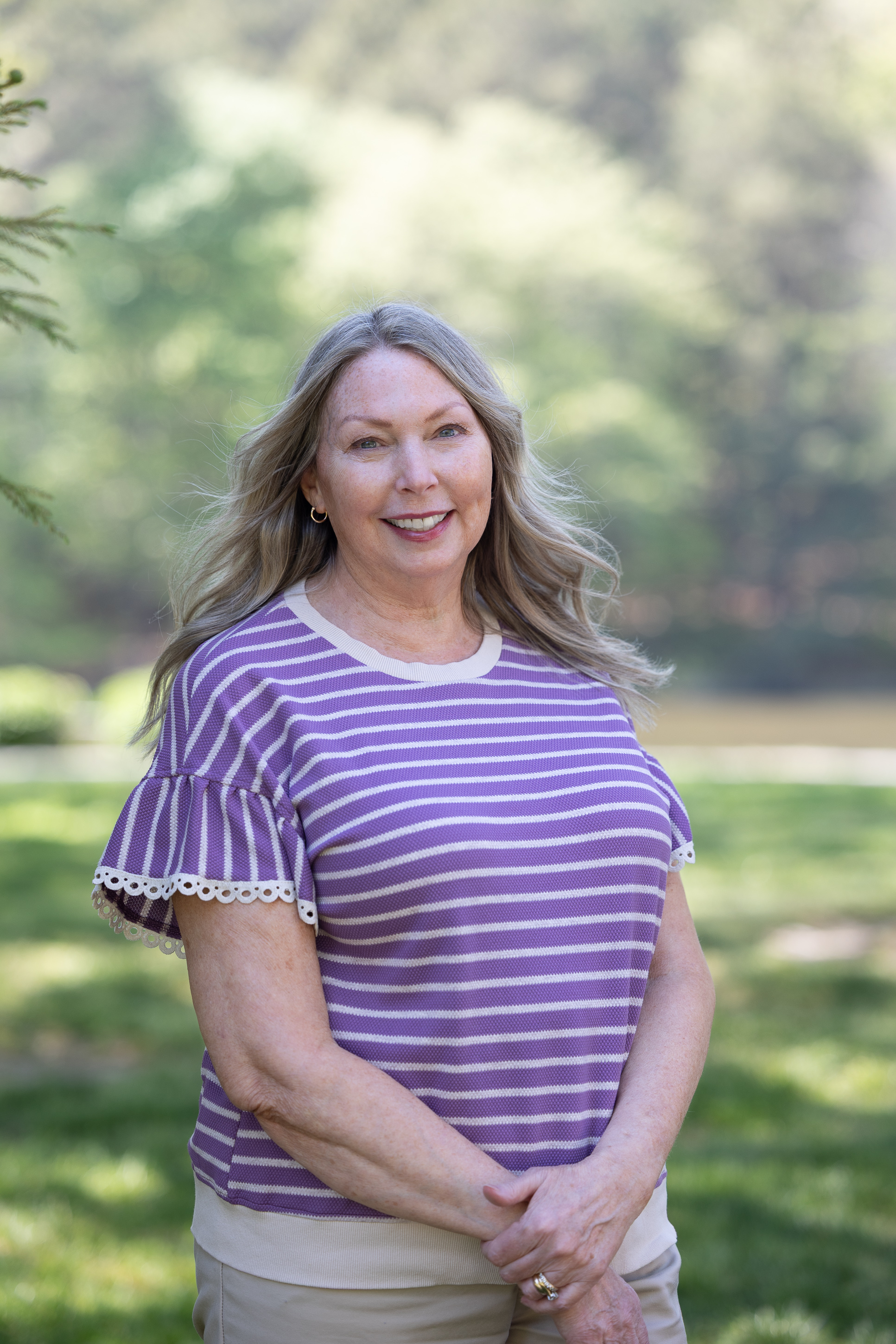 Smiling woman in purple striped top outdoors