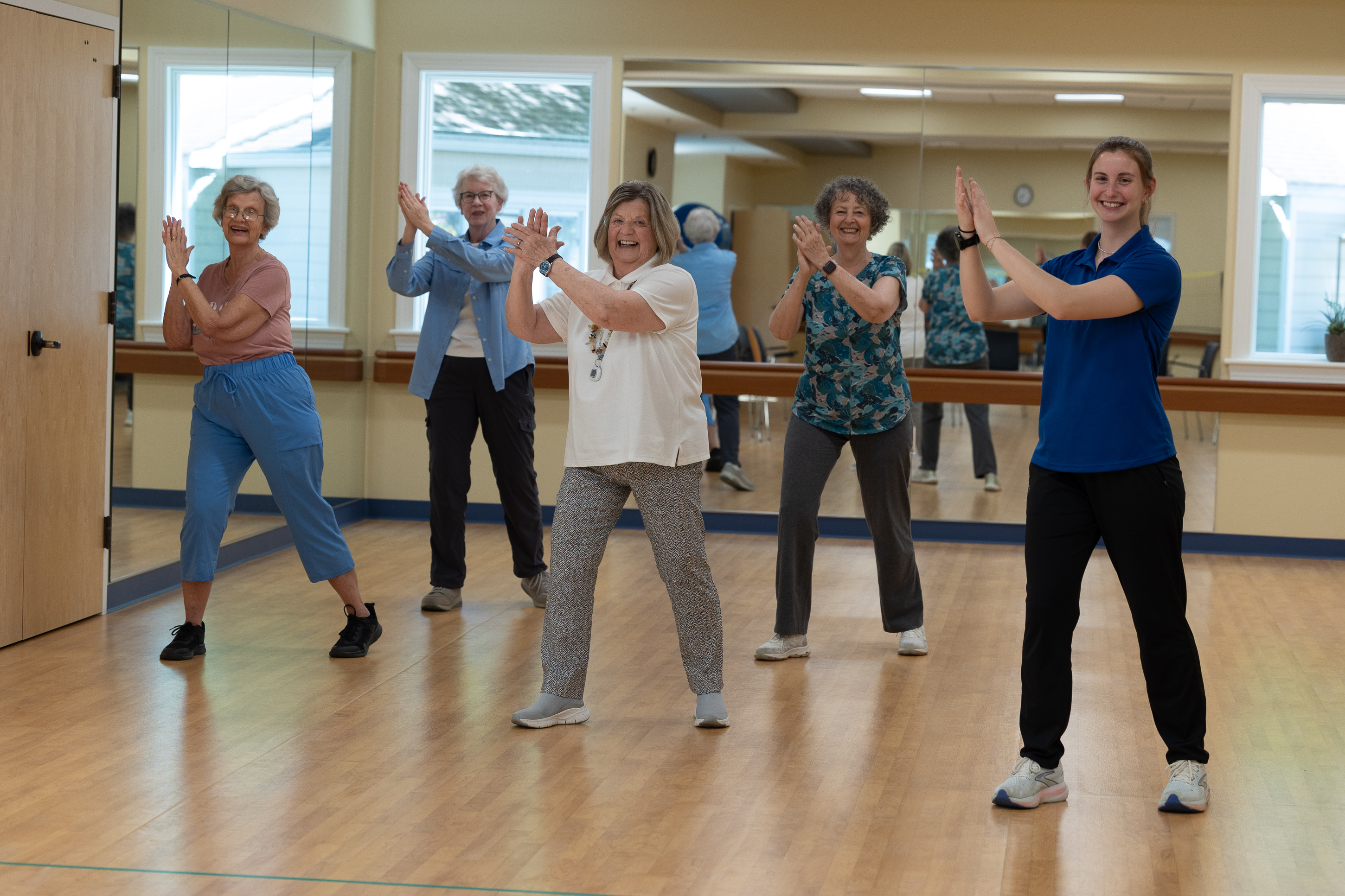 Senior women exercising in mirrored fitness studio
