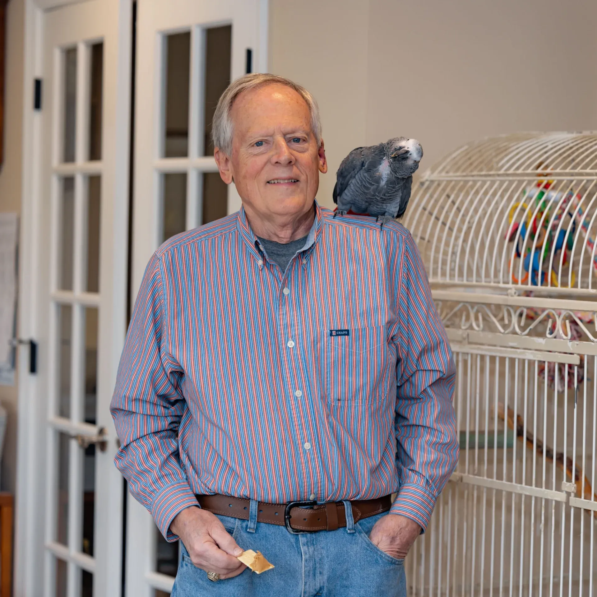 Man with parrot on shoulder indoors