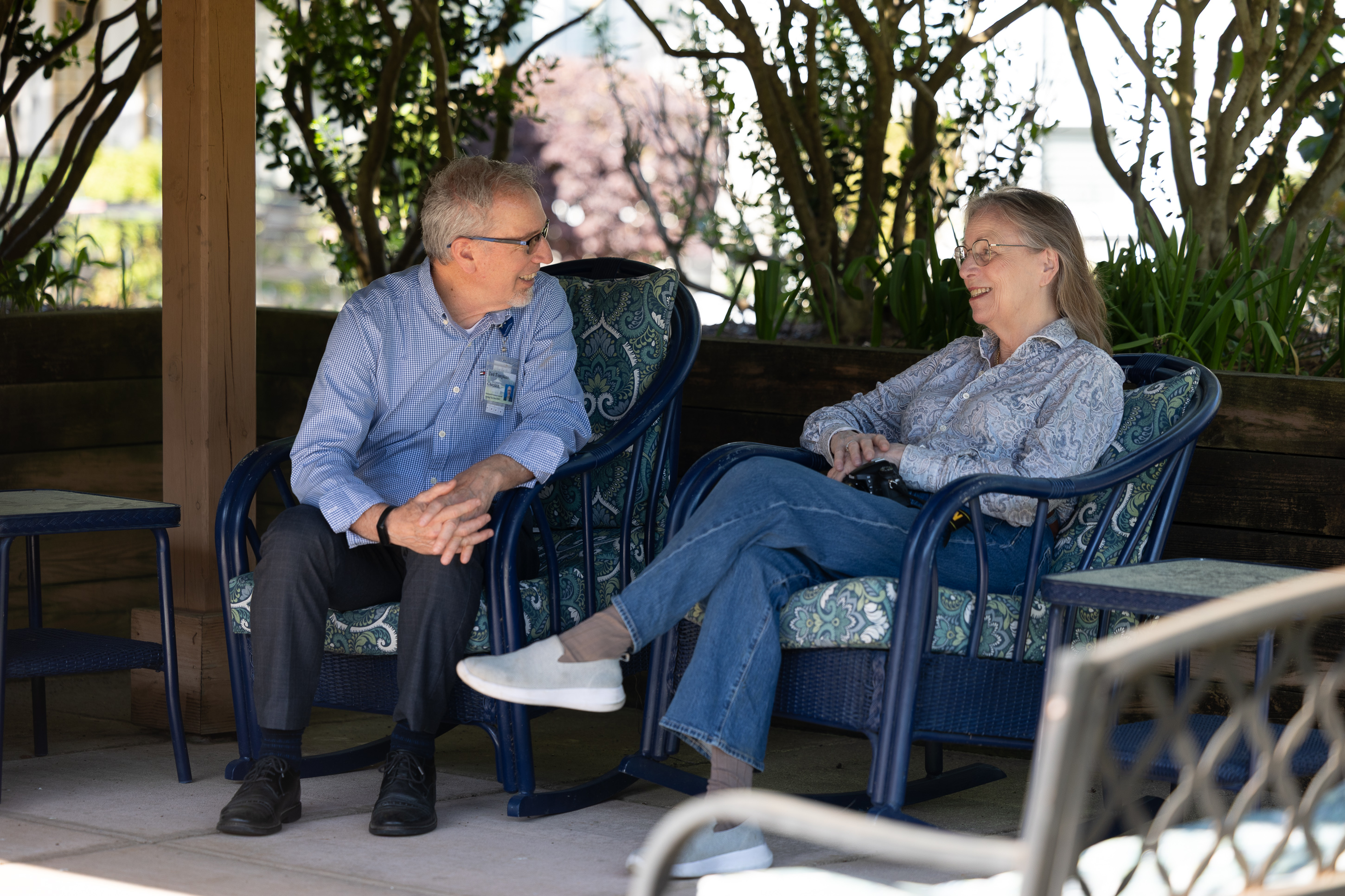 Two older adults chatting on outdoor patio