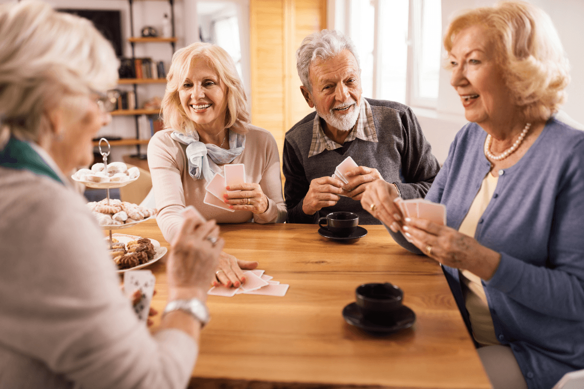 Four seniors playing cards at a table
