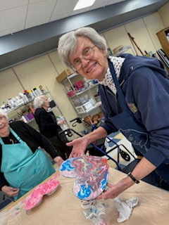 Woman holding painted brain model in art room