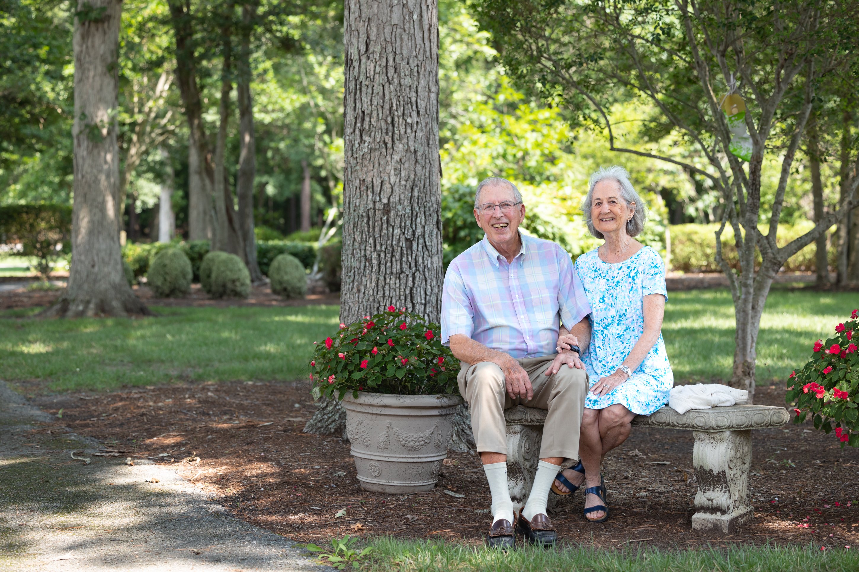 Elderly couple sitting on bench in park