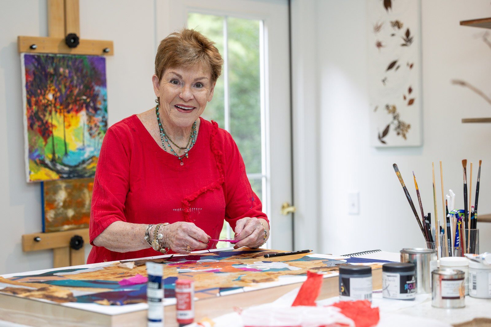 Senior woman painting at art studio table
