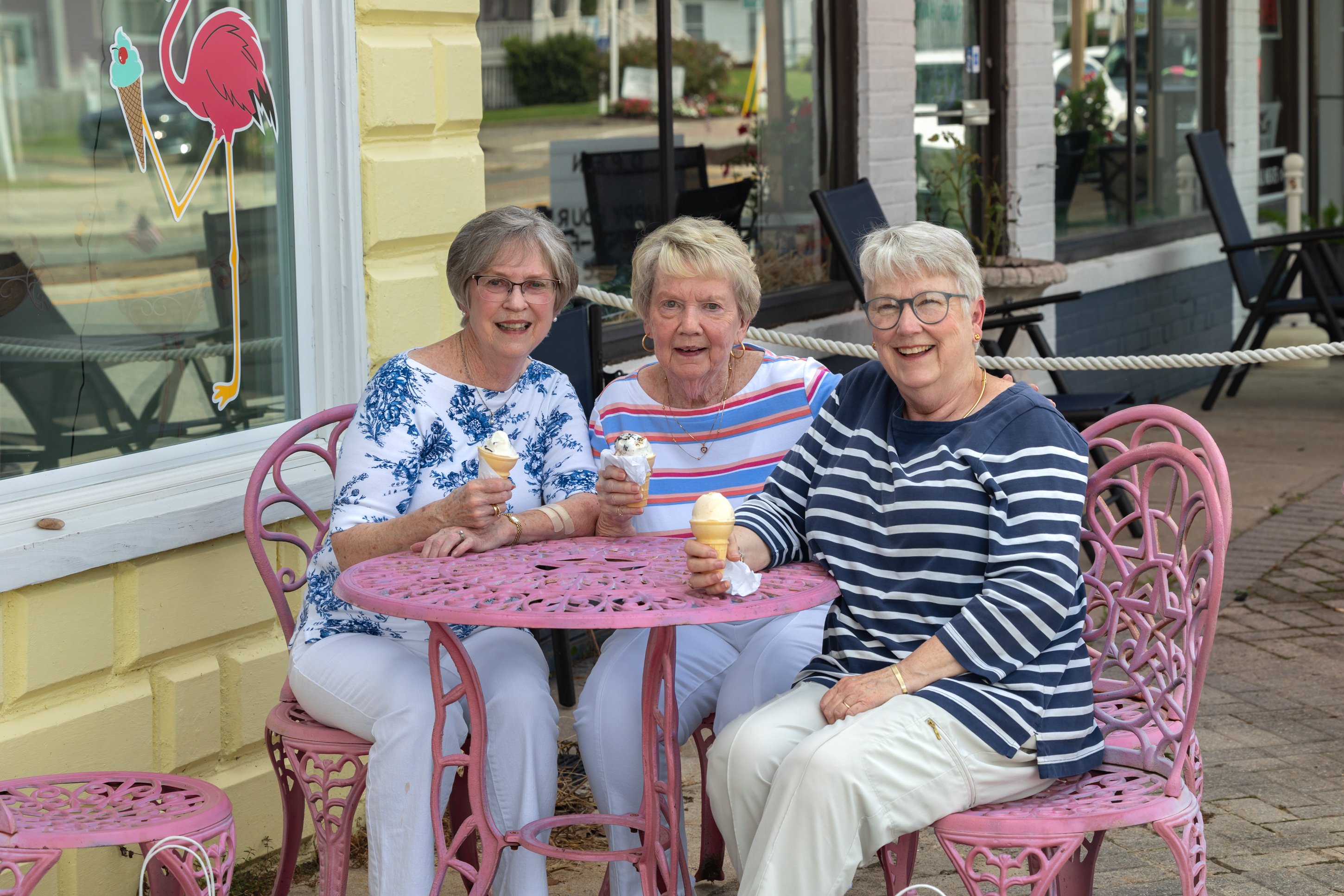 Three women enjoying ice cream at outdoor cafe