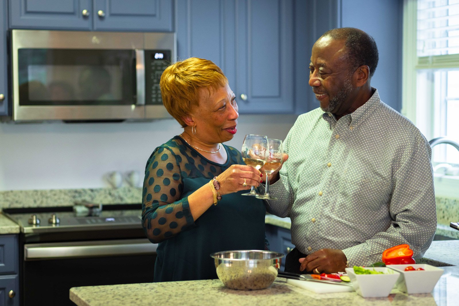 Couple toasting with wine in modern kitchen