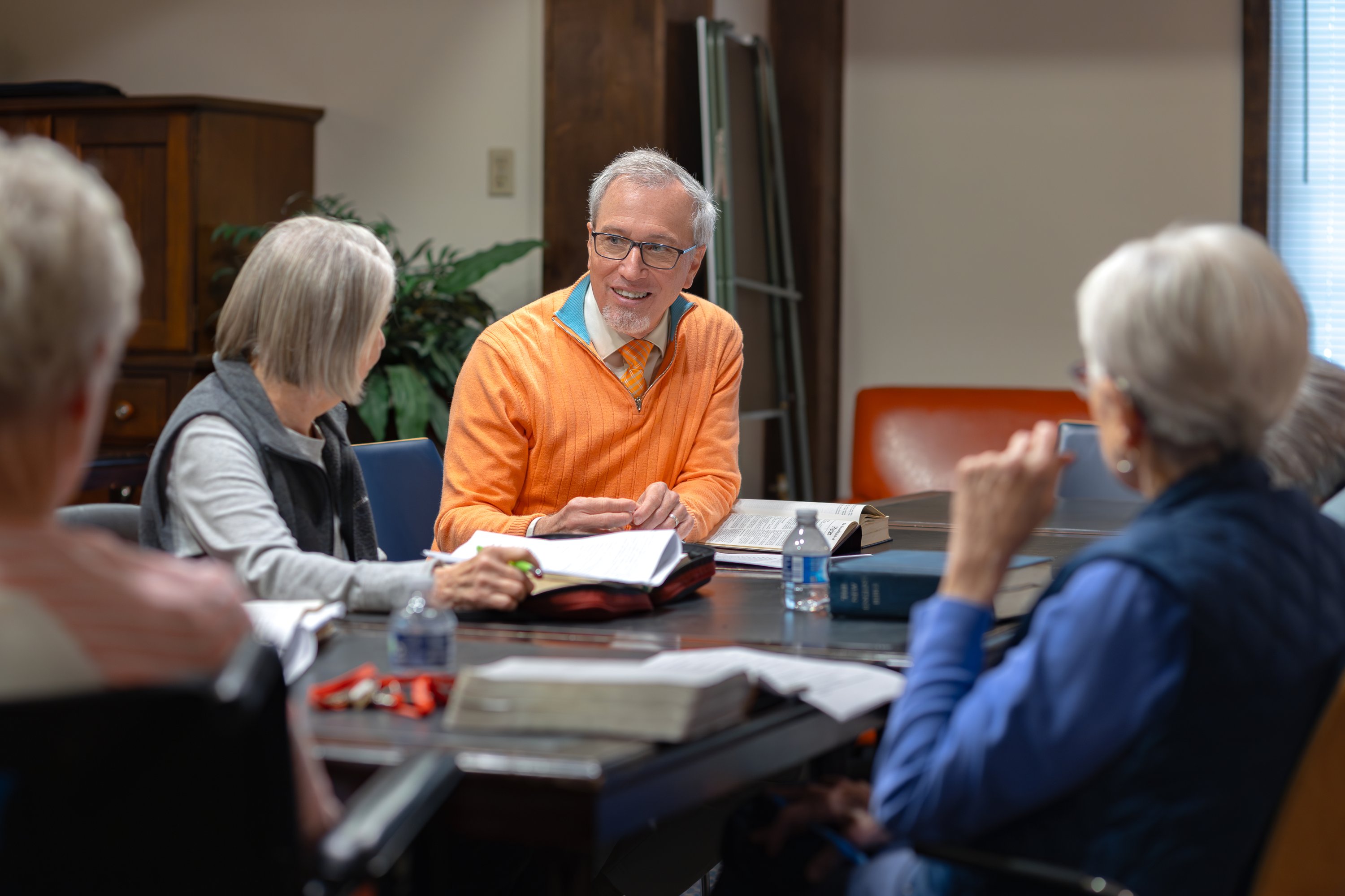 Older adults in group discussion with books