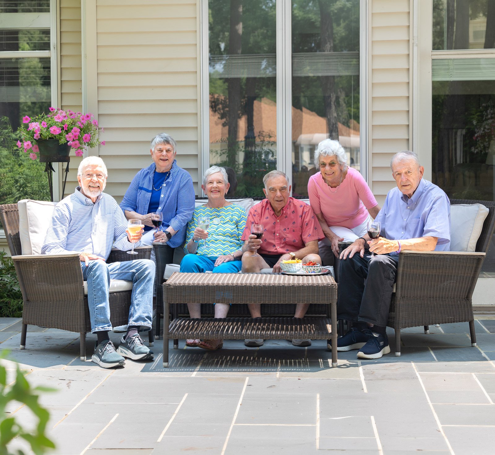 Six seniors enjoying drinks on outdoor patio