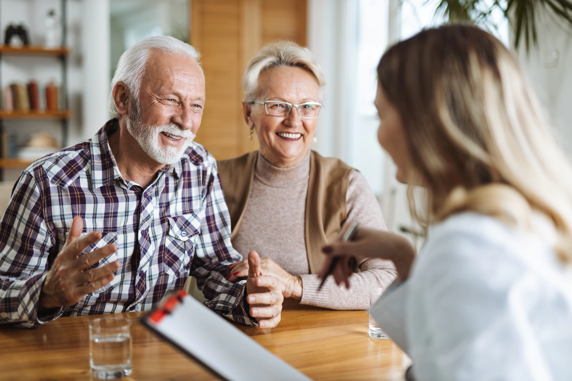 Smiling older couple talks with a young woman
