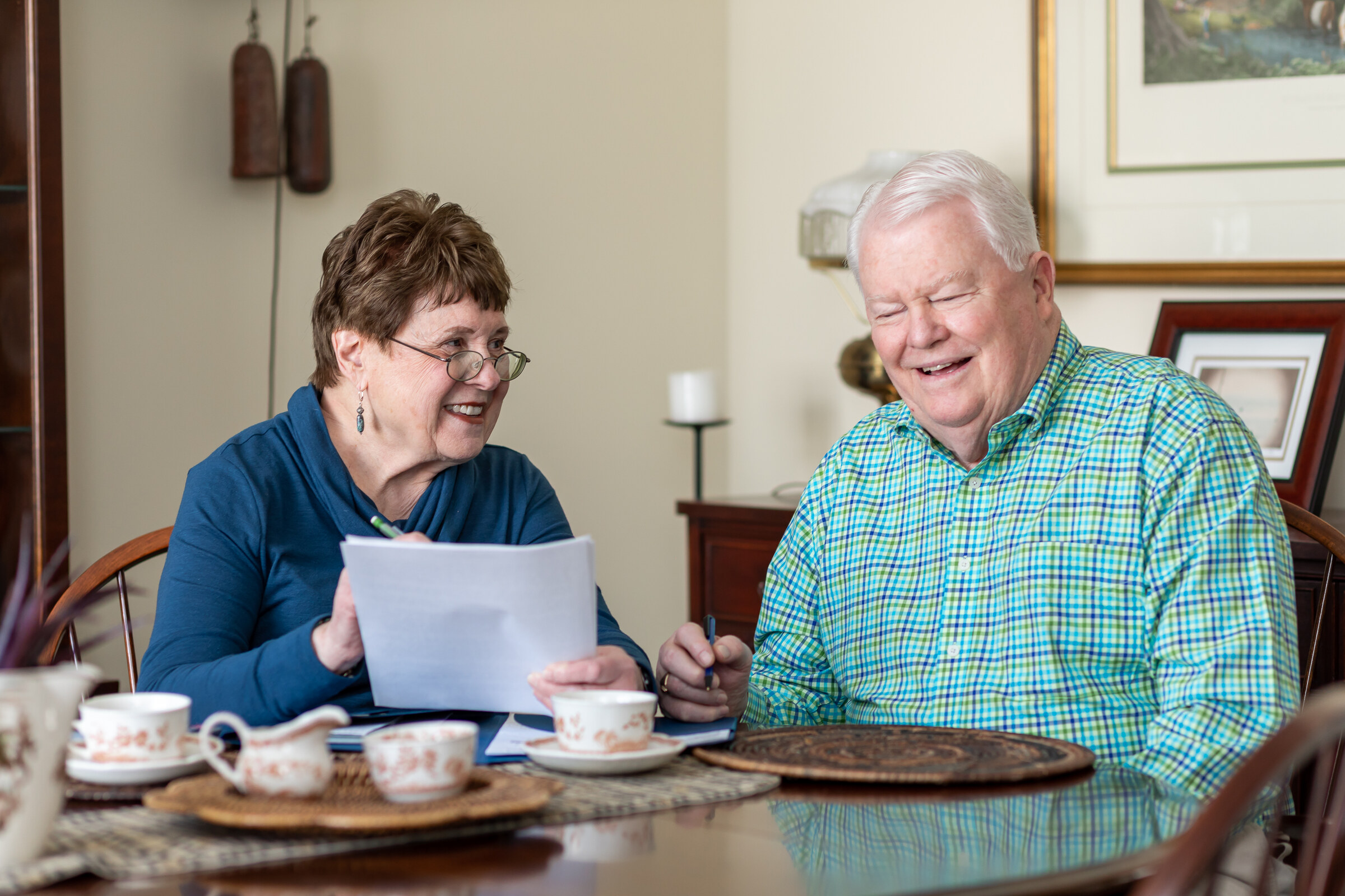 Senior couple reviewing paperwork at dining table