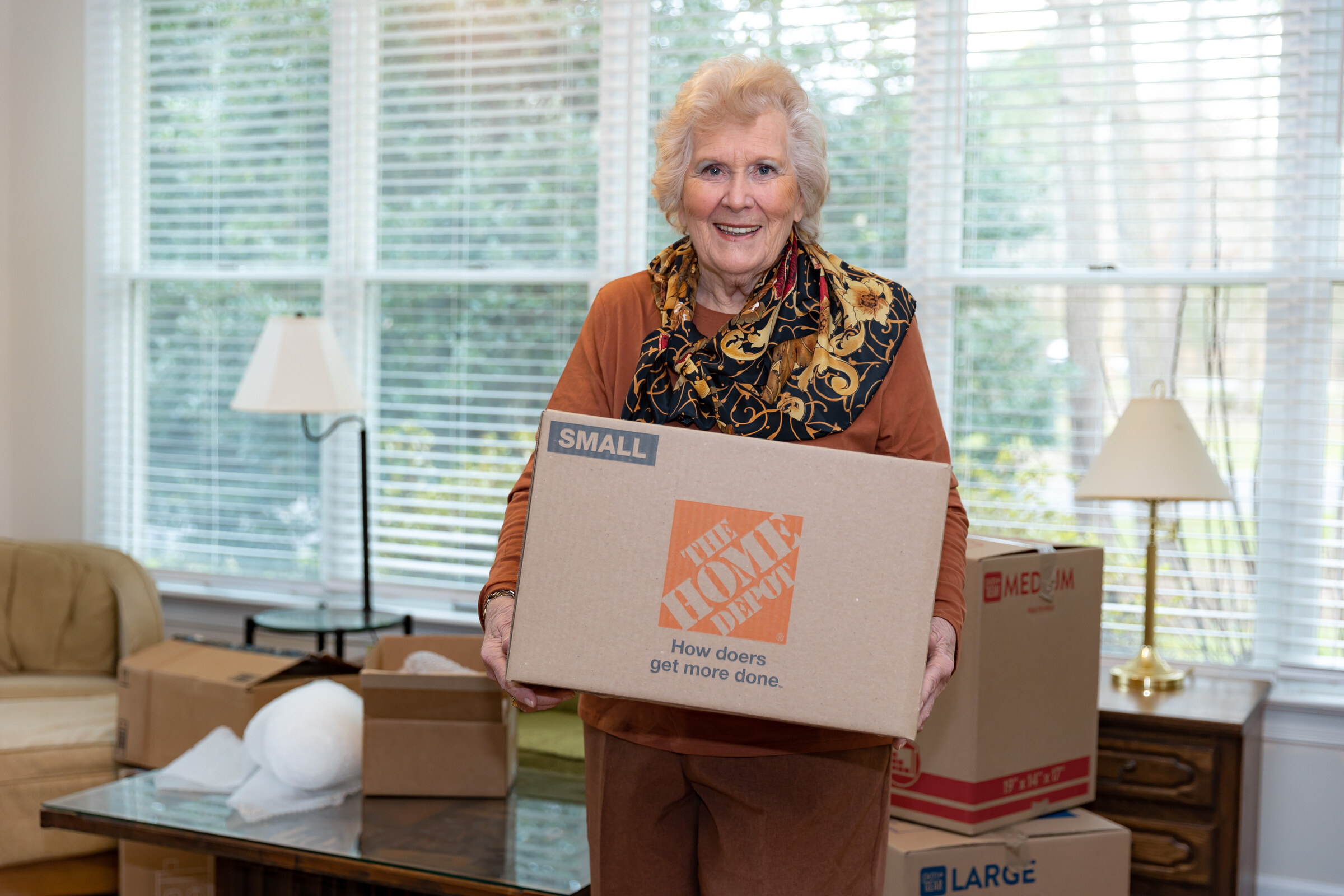 Senior woman holding Home Depot moving box indoors