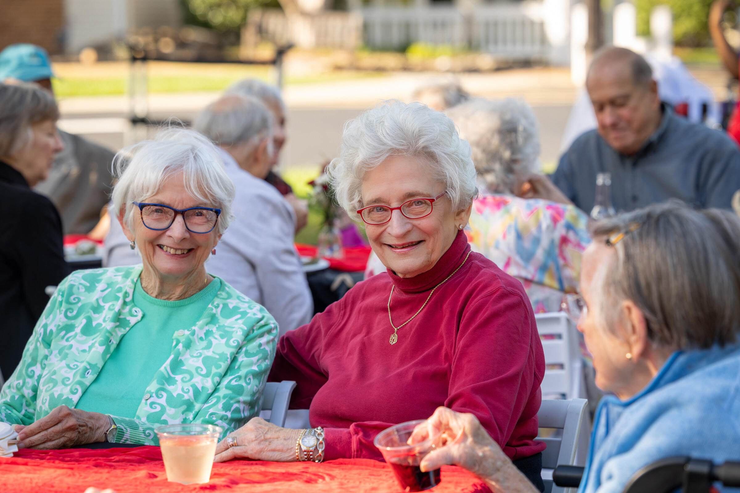 Senior women smiling at outdoor social gathering